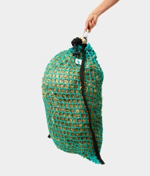 A hand holding a Forageplus slow feeder hay net