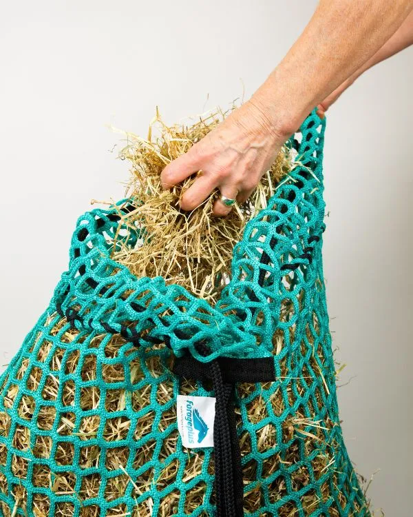 Filling a Forageplus knotless slow feeder hay net with hay