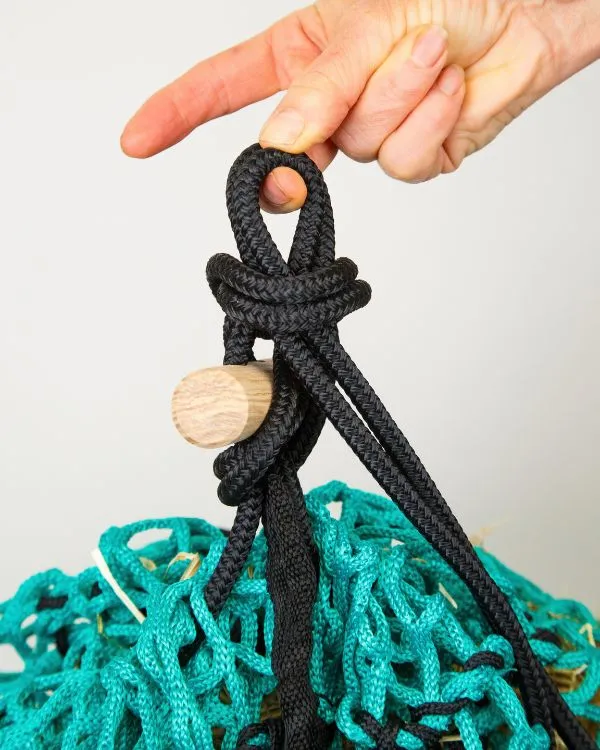 Tying off the rope on a closed Forageplus slow feeder hay net